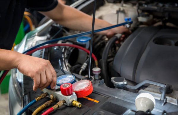 Auto mechanic monitor to check and fixed car air conditioner system in car garage. service car air conditioner in repair workshop. monitor tool on car engine ready to check and fixed air conditioner